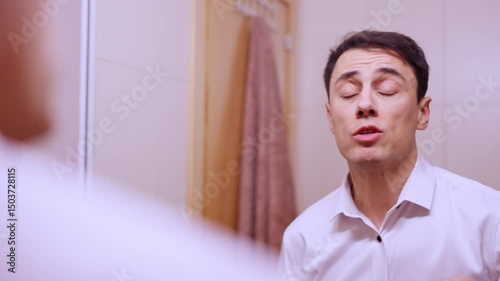 Nervous businessman rehearsing important speech in bathroom mirror