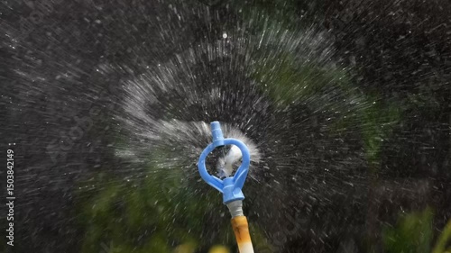 A footage of water sprinkler, spraying water at the garden.
