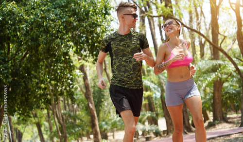 A man and a woman are jogging together in a beautiful park