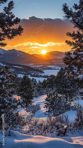A vibrant sun rises over distant mountains and snowy trees create a beautiful winter frame