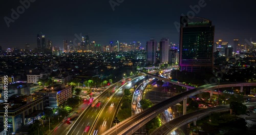 Aerial hyperlapse of Jakarta city with busy traffic on highway and glowing skyline at night, Indonesia. Perfect for urban, travel, and infrastructure themes. photo