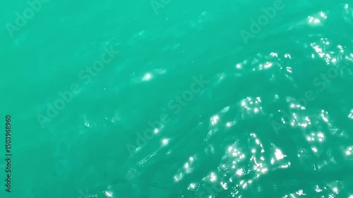 Calm blue ocean waves gently ripple across the surface, creating a serene and tranquil scene. The water showcases smooth textures and natural movement, evoking a sense of peace and relaxation.