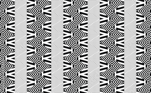 Intricate black and white pattern. Features bold vertical stripes with complex zigzag and linear designs, creating a striking abstract geometric background.