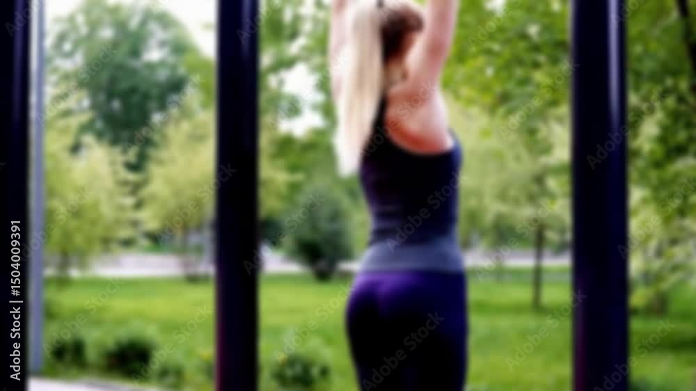 Blurred background of outdoor calisthenics with woman in slow pull-up form, 4K resolution
