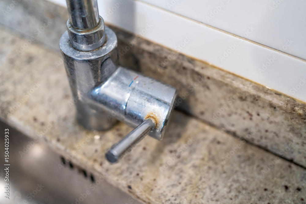 Obraz premium Dirty kitchen sink faucet contaminated with calcium and dirt.