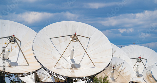 Close-up view of multiple large satellite dishes at a ground telecommunication station