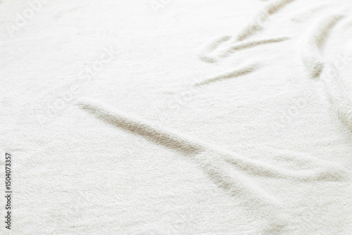 White soft shaggy blanket made of synthetic material close-up, texture for background