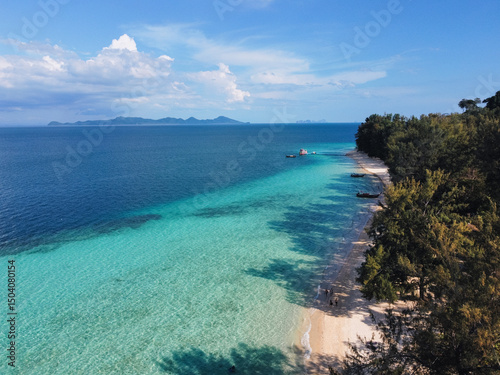 Captivating aerial view of a tropical beach with turquoise waters and boats swaying in a tranquil sea in Koh Kradan, Thailand photo