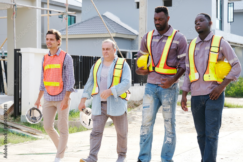 Obraz premium A team of male engineers wearing safety helmets is standing and planning at the construction site.