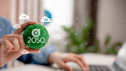 Sustainability and carbon neutrality goal for 2050, with hand holding green eco ball surrounded by CO2 icons, representing environmental commitment and climate action target.