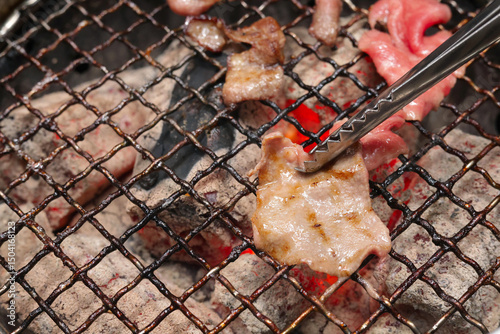 Close up of  beautifully marbled sliced beef grilled to perfection on a traditional Japanese-style grate. Traditional japanese food.   