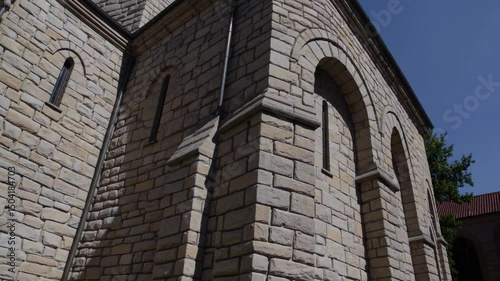 Romanesque church wall with arched windows and thick stone masonry

