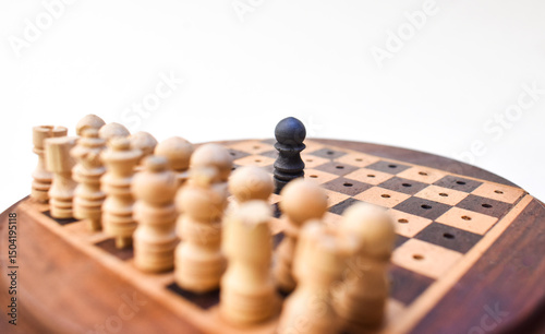one black chess piece against all. concept of competition background. wooden chessboard.