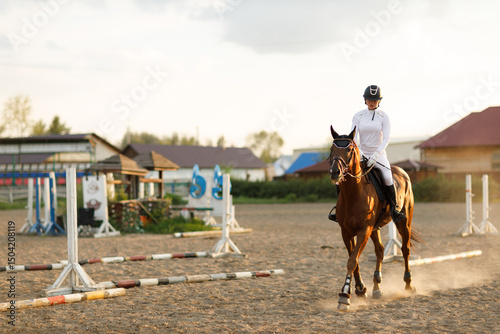 Woman rider jockey in helmet and white uniform preparing horse racing