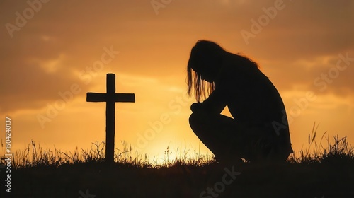 Female silhouette on knees in worship at cross during sunset, quiet strength of faith