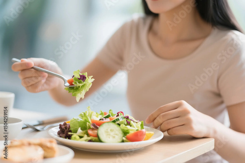 Woman eating a plate of salad 