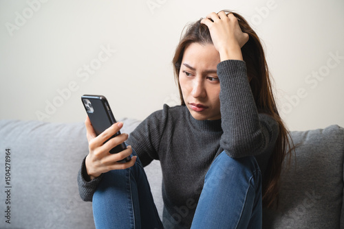 Wallpaper Mural anxious girl looking at mobile phone and worry about bully text in social media. Torontodigital.ca