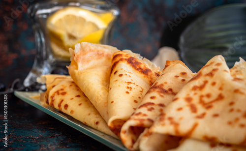 Pila de crepes caseras frescas con limón sobre fondo rústico