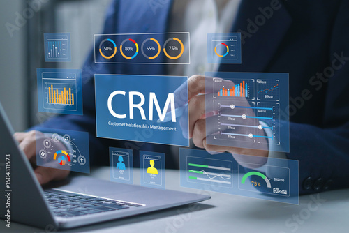 Customer relationship management software concept. CRM for sales, Sales control and monitoring software with client database. Businessman using laptop with CRM icon on virtual screen.