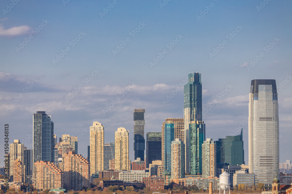 Obraz premium Panoramic view of Lower Manhattan skyline featuring One World Trade Center, seen from across the Hudson River on a clear day in New York City.