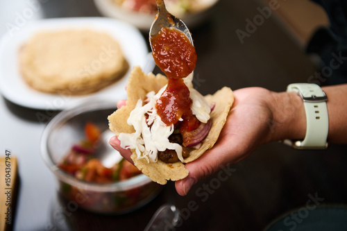 Close-Up View of a Person Adding Sauce to a Homemade Taco