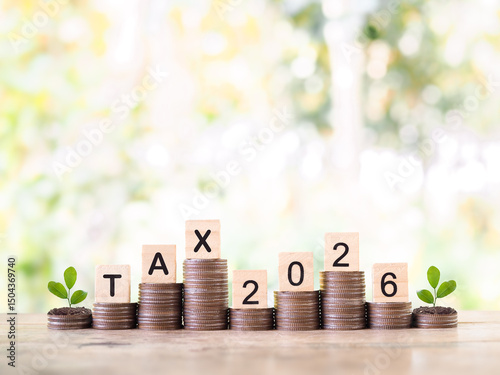 Wooden blocks with the word TAX, Number 2026 and plants growing up stack of coins. The concept of saving money for payment tax, Financial, Investment and Business growing up.