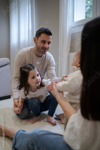 Happy family playing with baby on the floor