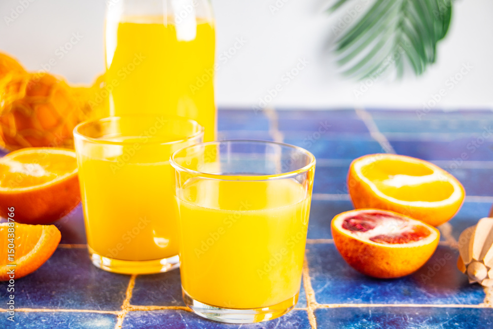 Fototapeta premium Fresh orange juice on table with slices fruits.
