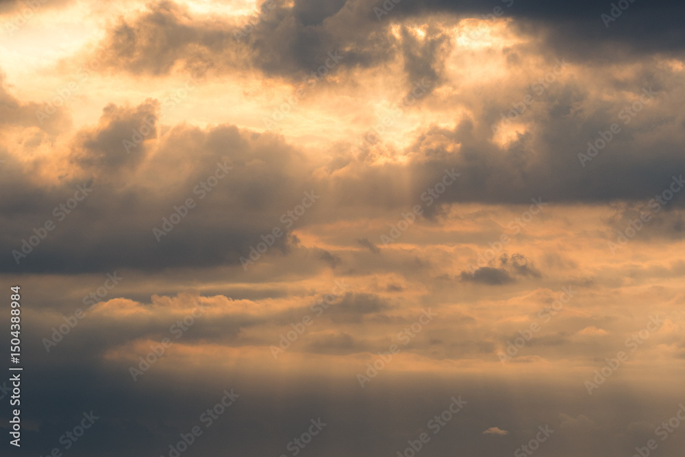 Obraz premium Golden Sunset Sky with Sun Rays Breaking Through Clouds