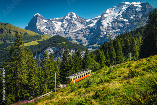 Electric train and Jungfrau mountains in background, Murren, Switzerland