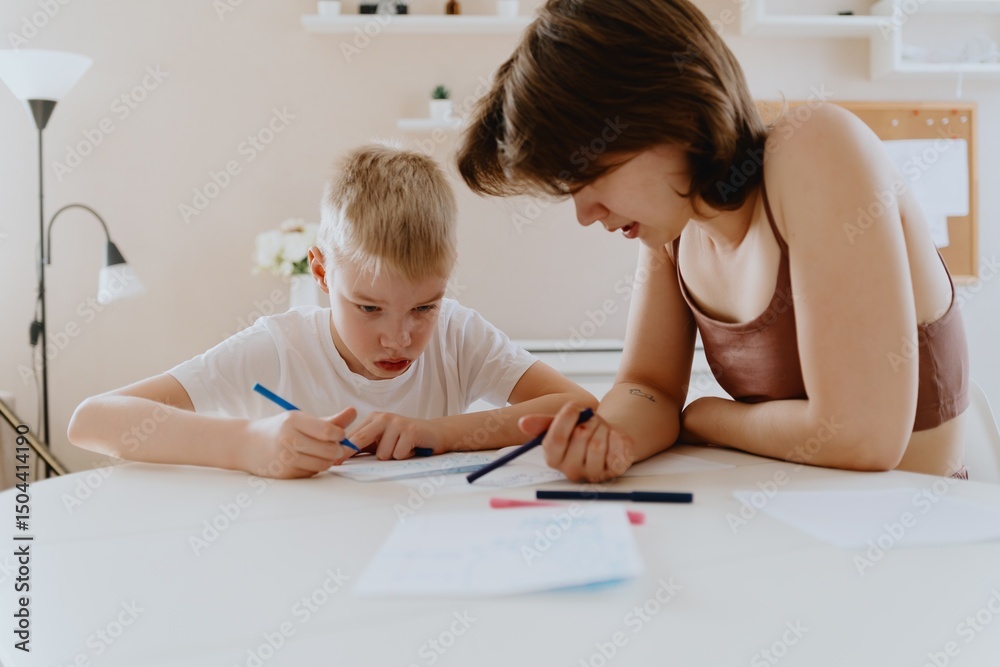 A loving mother and her son work together on homework at the kitchen table, symbolizing family support, education, and care. The scene highlights the importance of parental guidance A loving mother and her son work together on homework at the kitchen table, symbolizing family support, education, and care. The scene highlights the importance of parental guidance