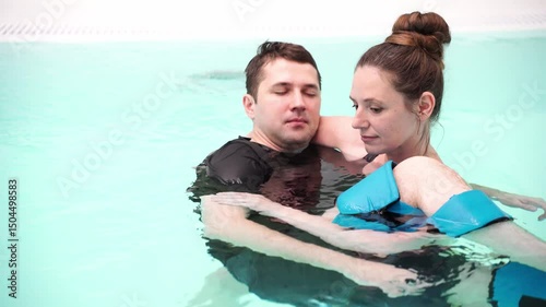Couple relaxing in pool embrace tranquil water moments captured in slow motion.