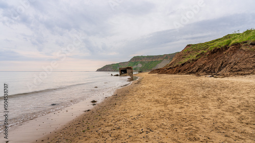 A destroyed World War II bunker on the beach of Cayton Bay, England, UK