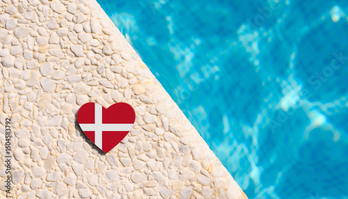 Denmark flag in the shape of a heart near a hotel pool.