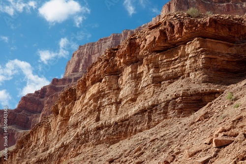 Wallpaper Mural Visitors admire the towering rock formations in a desert canyon. Sunlight illuminates the vibrant colors of the cliffs against a backdrop of scattered clouds Torontodigital.ca