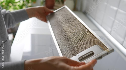 Dirty greasy kitchen hood filter that not clean for long time. Man hands check broken dirty grid, dust food grease accumulation, air quality risk, prevention of respiratory issue, maintenance neglect