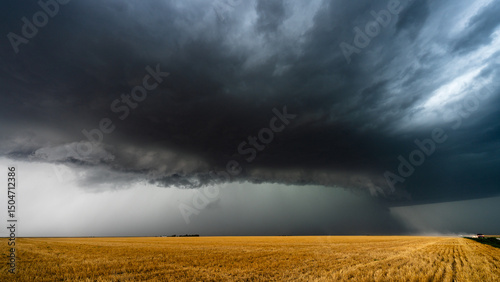 Big  powerful storm over fields with cars driving on dusty road