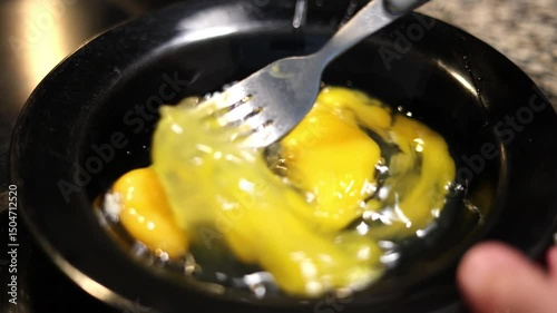 Scrambling Eggs In A Black Bowl