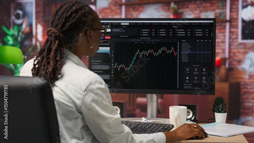 Day trader using PC to purchase and sell stocks, reading files, aiming to capitalize on market trends and fluctuations. Investor tracking stock forex trends on computer monitor, camera B
