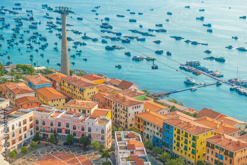 Foto Aerial view of colorful coastal town with Mediterranean style buildings, marina full of boats and cable car over the sea on Phu Quoc island, Vietnam at Sunset town