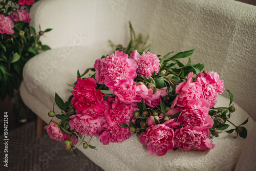 Bouquet of beautiful peonies on a pouf indoors