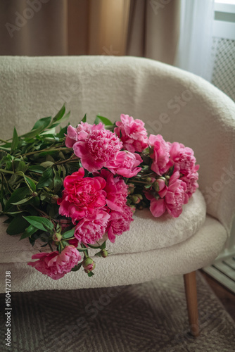 Bouquet of beautiful peonies on a pouf indoors