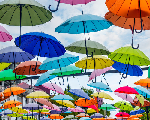 Countless umbrellas of different colors create a colorful canopy over the street. An original decoration of urban space.