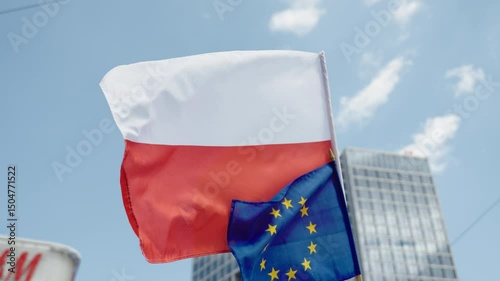 Polish and European Union flags waving in the wind. Symbol of international unity and cooperation. Ideal for political and documentary projects.