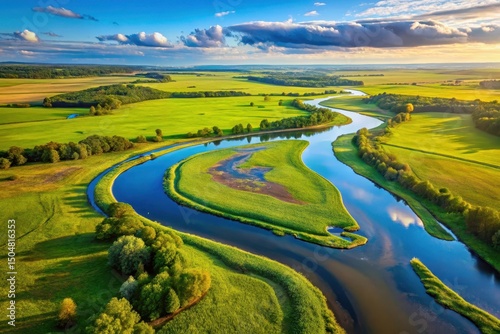 Aerial View of Serene River Meandering Through Lush Green Fields Under a Dramatic Sky photo