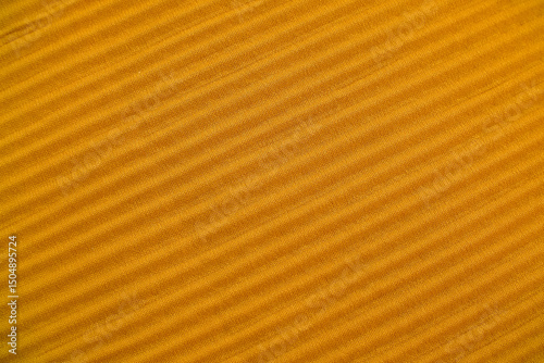 High-resolution macro photograph showcasing a rich mustard yellow fabric texture. The image captures the detailed weave of the fibers, creating a tactile, warm-toned, and high-quality textile surface.
