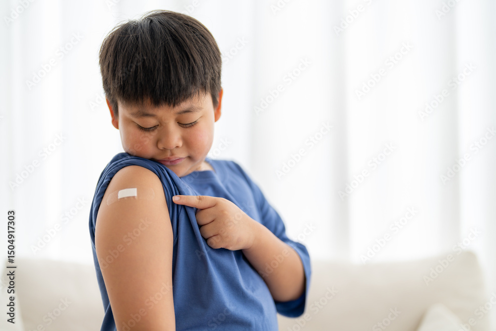 Portrait of happy smile vaccinated little asian kid boy children ages 5 to 11 years old posing show arm with medical plaster after Injection vaccine Covid-19 protection.coronavirus vaccination kid Portrait of happy smile vaccinated little asian kid boy children ages 5 to 11 years old posing show arm with medical plaster after Injection vaccine Covid-19 protection.coronavirus vaccination kid