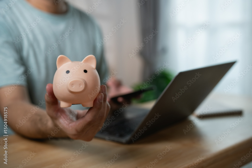 Person Holding Piggy Bank in Front of Laptop for Online Banking and Financial Management in Modern Home Office Setting Person Holding Piggy Bank in Front of Laptop for Online Banking and Financial Management in Modern Home Office Setting