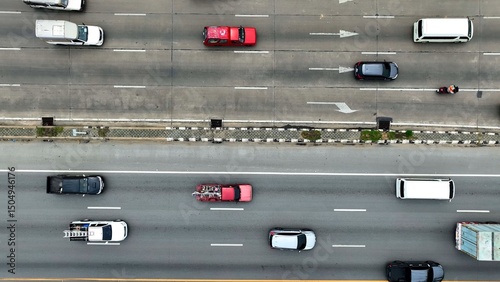 An aerial vista reveals a multi-lane artery, meticulously marked with lane delineations. Vehicles of diverse sizes and shapes navigate, orchestrated by traffic rules.
