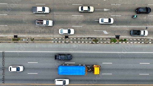 From above, a bustling thoroughfare unfolds, a symphony of motion. Cars weave like dancers, a giant truck leading the orchestra. Lane lines guide their harmonious journey.
